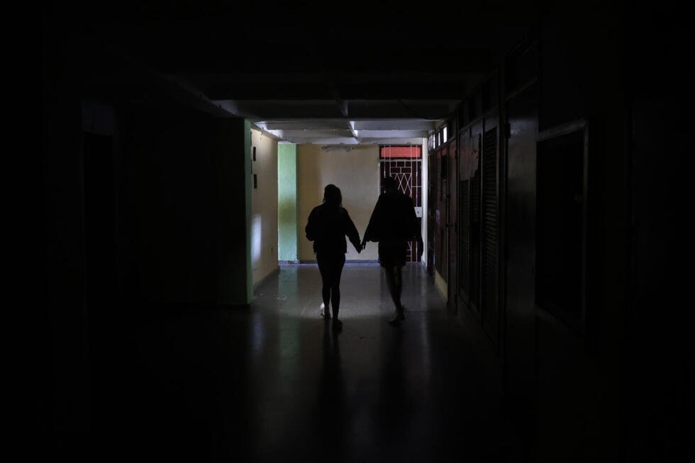 Personas iluminan con un teléfono el interior de un edificio afectado por los apagones en La Habana (Cuba), el 13 de febrero de 2026.