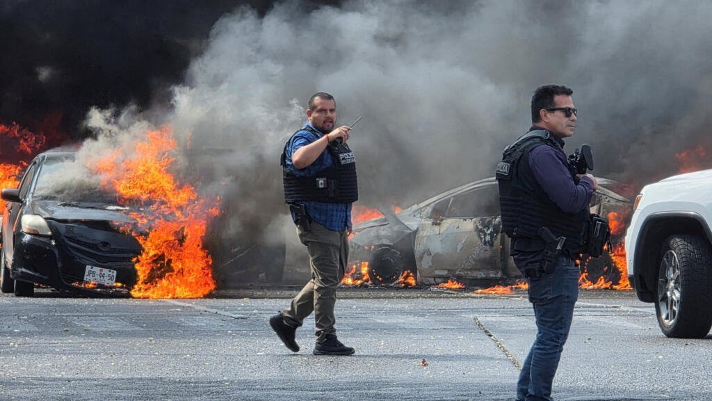 Des voitures qui brûlent dans la ville de Zapopan au Mexique pour bloquer des routes au lendemain de la mort du narcotrafiquant mexicain Ruben Nemesio Oseguera Cervantes, alias "El Mencho".