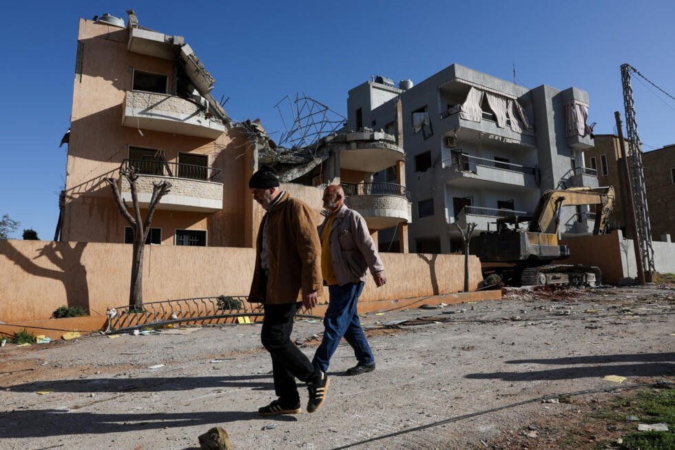 Habitantes pasan al lado de un edificio dañado, tras un ataque israelí, en Riyak, valle de Bekaa, en Líbano, el 21 de febrero de 2026.