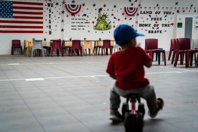 Un niño inmigrante juega frente a frases y símbolos patrióticos que cubren las paredes de un gimnasio mientras el Servicio de Inmigración y Control de Aduanas de Estados Unidos (ICE) organiza una visita para los medios de comunicación al Centro Residencial Familiar del Sur de Texas, que alberga a familias que están a la espera de la resolución de sus casos de inmigración, el viernes 23 de agosto de 2019 en Dilley, Texas.