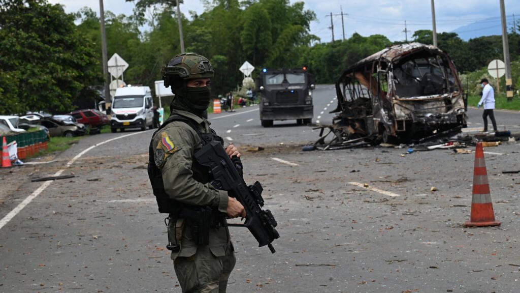 Un policía monta guardia en el lugar donde explotó un autobús frente a una comisaría en Villa Rica, departamento del Cauca, Colombia, el 10 de junio de 2025. El suroeste de Colombia se vio sacudido por una serie de explosiones y ataques con armas de fuego.