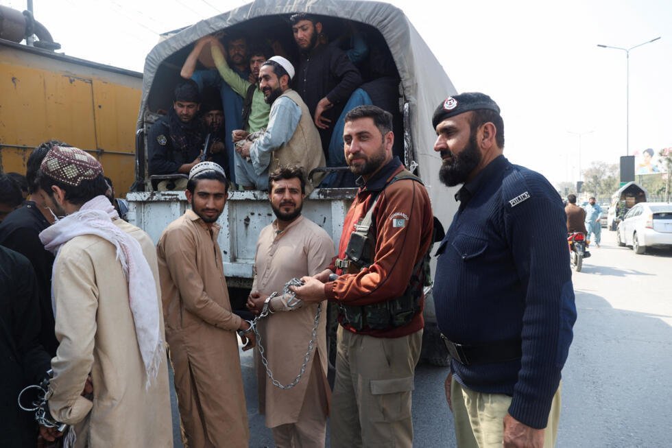 Refugiados afganos arrestados en diferentes zonas son llevados ante los tribunales en un vehículo policial en Peshawar, Pakistán, el 1 de marzo de 2026.