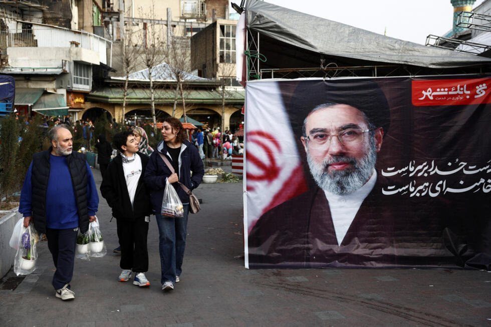 Personas caminan junto a una pancarta con la imagen del nuevo líder supremo de Irán, Mojtaba Jamenei, en el bazar Tajrish, antes de Nowruz, el Año Nuevo iraní, en medio del conflicto entre Estados Unidos e Israel con Irán, en Teherán, Irán, el 19 de marzo de 2026.