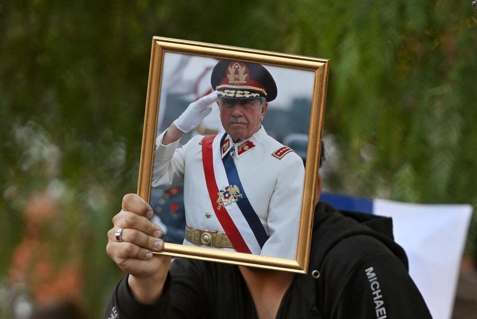 Un homme brandit un portrait d'Augusto Pinochet à Santiago après l'élection de José Antonio Kast, le président le plus à droite du Chili depuis 35 ans, le 14 décembre 2025