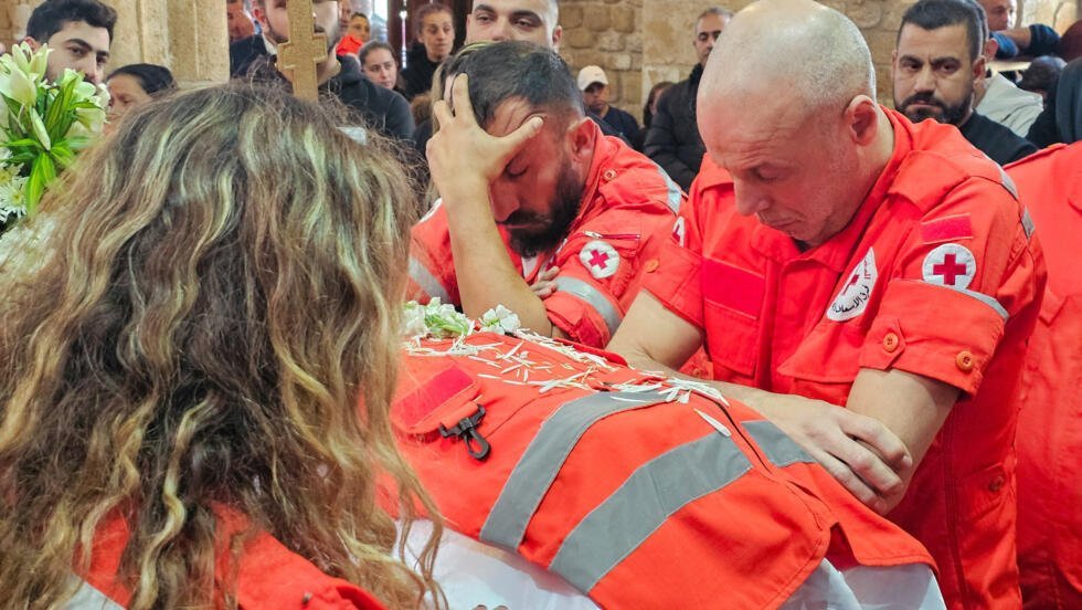 Voluntarios de la Cruz Roja Libanesa junto al ataúd de su colega, el paramédico Youssef Assaf, durante su funeral en la ciudad sureña de Tiro, Líbano, el 11 de marzo de 2026.