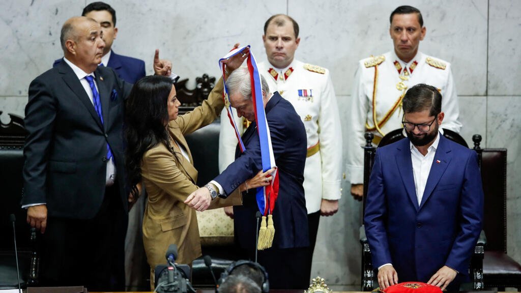 El presidente electo de Chile, José Antonio Kast, recibe la banda presidencial de manos de la senadora Paulina Núñez, mientras el presidente saliente de Chile, Gabriel Boric, observa en el Congreso, en Valparaíso, Chile, el 11 de marzo de 2026.