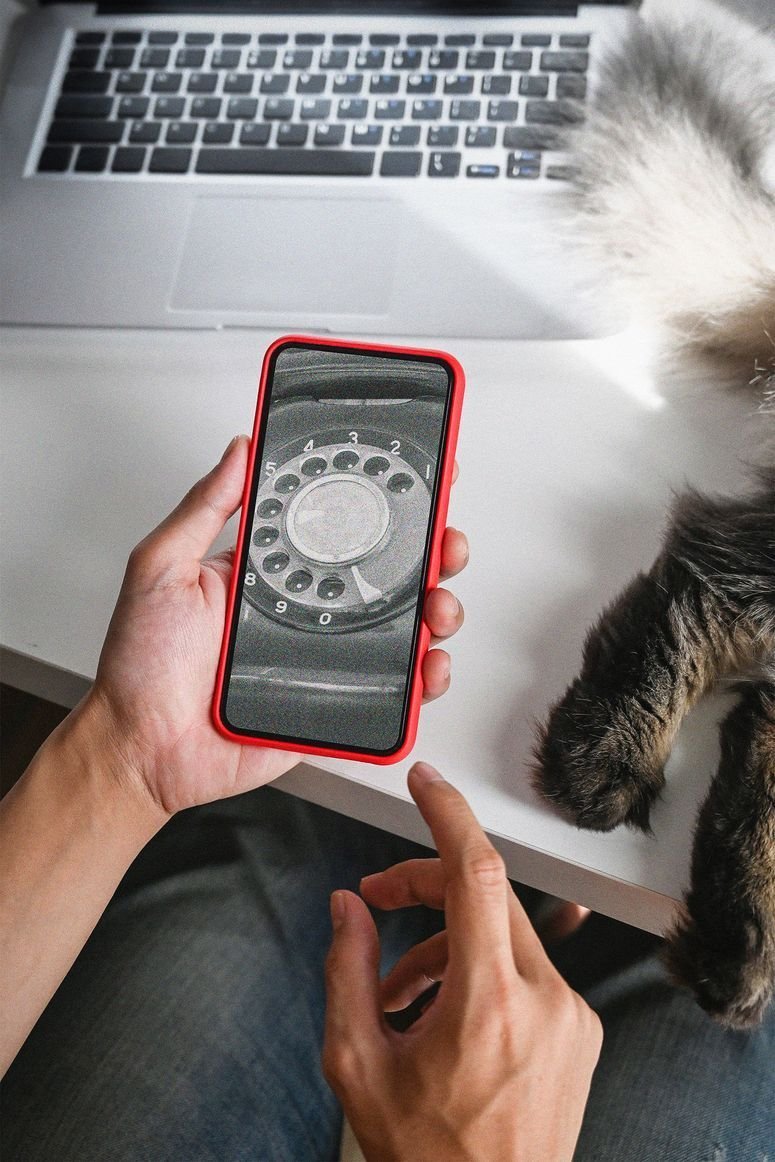 Persona sosteniendo un smartphone con una aplicación de teléfono en la pantalla. 