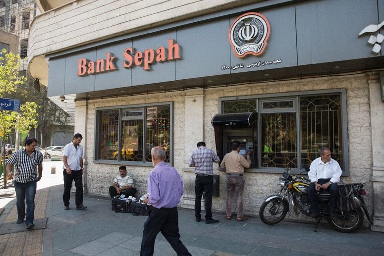 Clientes usan un cajero automático (ATM) afuera de una sucursal del Banco Sepah en Teherán, Irán.