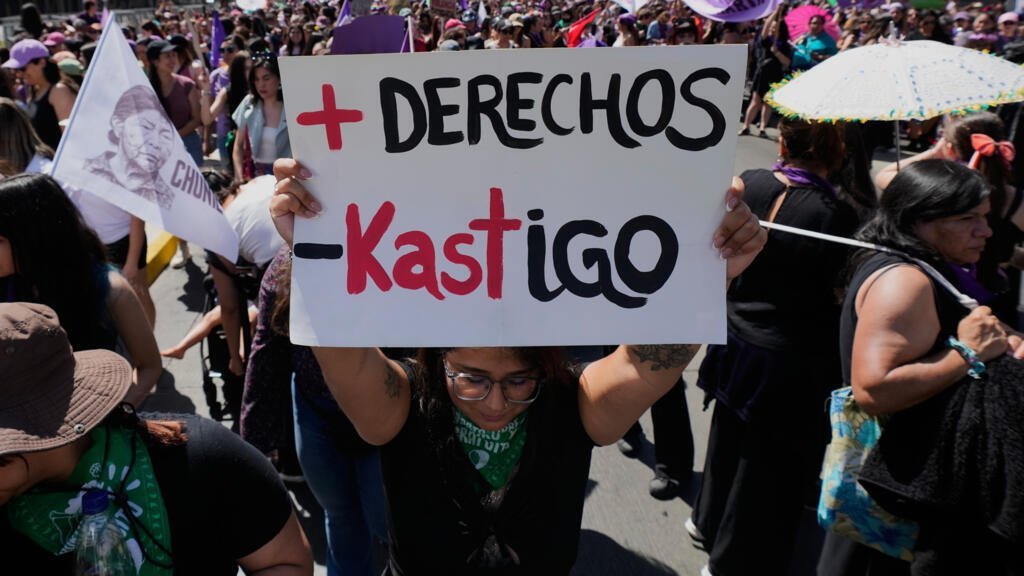 Una mujer sostiene una pancarta en la que se lee en español «Más derechos, menos castigo», en un juego de palabras que hace referencia al presidente electo de Chile, José Antonio Kast, durante una manifestación con motivo del Día Internacional de la Mujer celebrada en Santiago de Chile el domingo 8 de marzo de 2026.