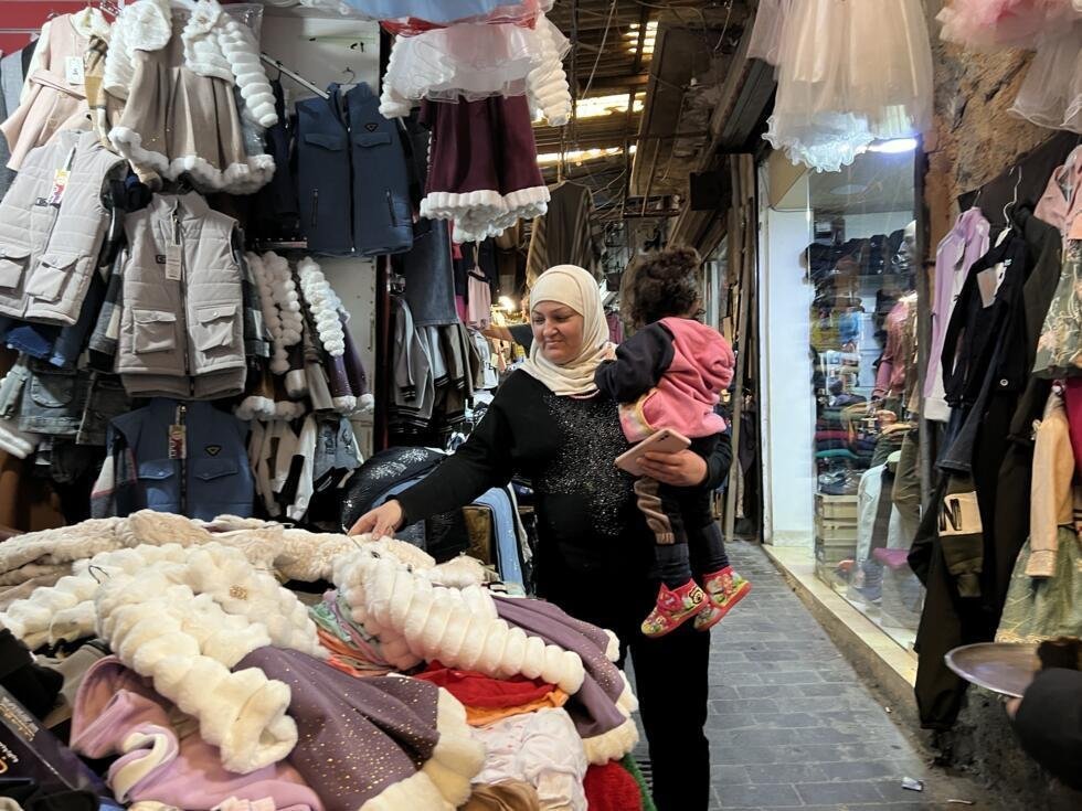 Dania choisit une robe pour sa petite-fille de cinq ans dans le souk de Saïda