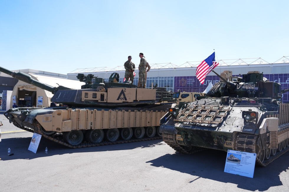 Foto de archivo. Personal del Ejército de los Estados Unidos posa sobre un tanque de combate principal M1A2 Abrams junto a un vehículo de combate de infantería M2A3 Bradley, expuestos en la Feria Mundial de Defensa celebrada en Riad, Arabia Saudita, el domingo 8 de febrero de 2026.