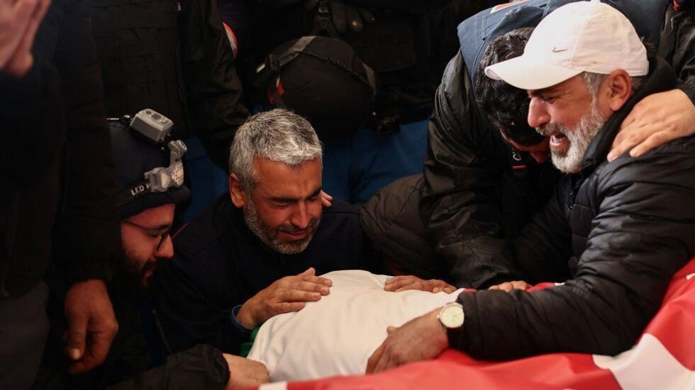 Dos hombres lloran sobre los cuerpos de dos paramédicos que murieron en un ataque israelí, en medio de la escalada de hostilidades entre Israel y Hezbolá, en Nabatieh, Líbano, el 25 de marzo de 2026.