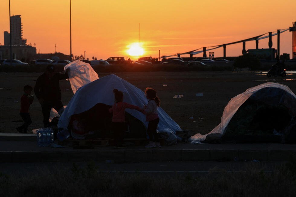 Un hombre desplazado sostiene unas láminas de plástico, que se utilizarán en una tienda de campaña para protegerse de la lluvia, tras la escalada de tensión entre Hezbolá e Israel, en medio del conflicto entre Estados Unidos e Israel con Irán, en Beirut, Líbano, el 17 de marzo de 2026.