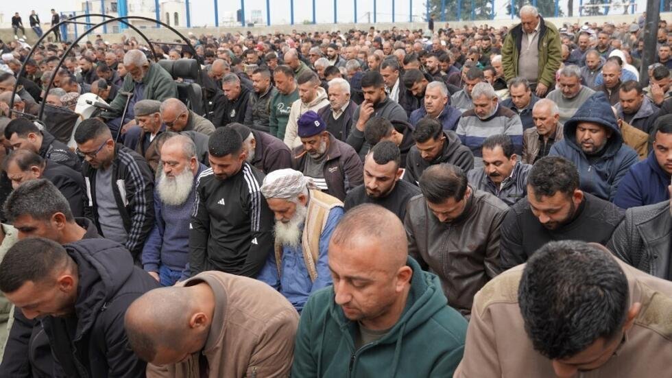 Vecinos de Beit Awwa rezan durante el entierro de las primeras palestinas de Cisjordania asesinadas por un misil iraní.