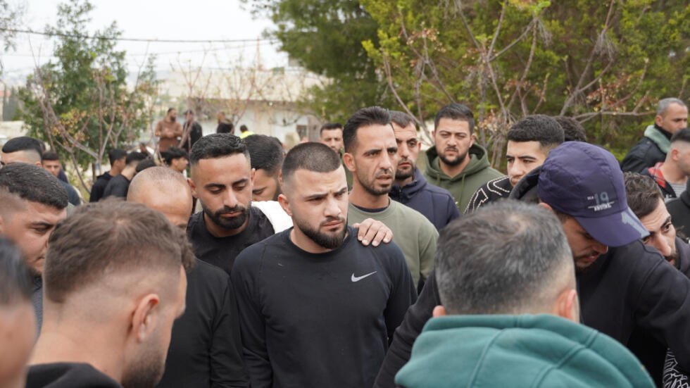 En el centro, el hermano de Sahera, dueña del salón en el que murieron cuatro palestinas, víctimas de la guerra Israel-Irán.