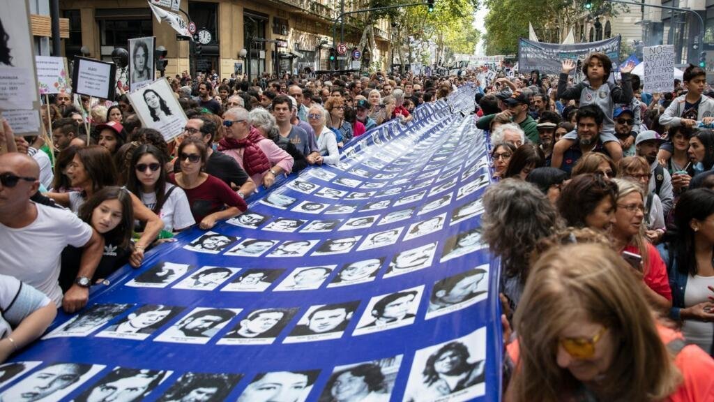 Archivo. Miembros de la organización de derechos humanos ‘Madres de Plaza de Mayo’ y activistas llevan una gran pancarta con retratos de personas desaparecidas en la dictadura militar de 1976-1983, durante una marcha hacia la Plaza de Mayo para conmemorar el 43 aniversario del golpe de Estado de 1976. En Buenos Aires, Argentina, el 24 de marzo de 2019.