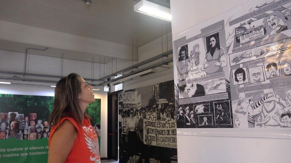 En la Casa por la Identidad, María Paula Inama Macedo mira la historieta que cuenta la historia de sus padres desaparecidos por la dictadura.