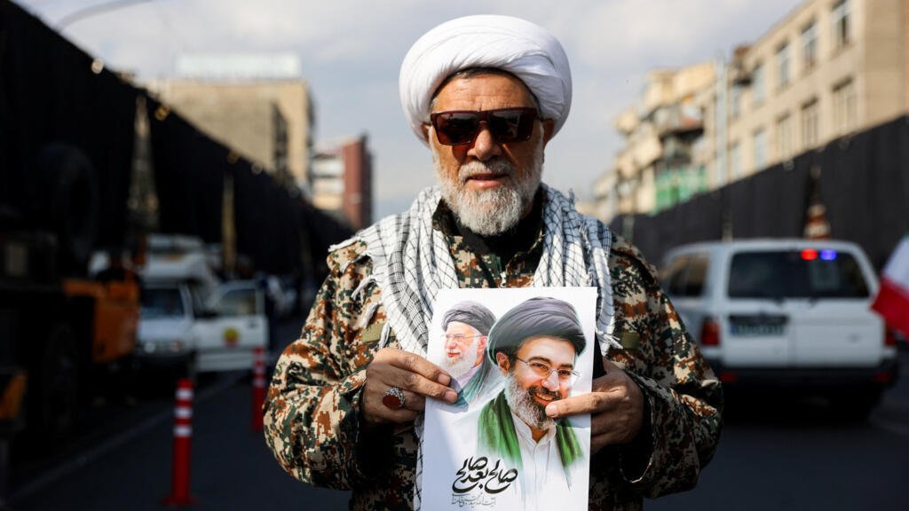 Un hombre sostiene un cartel con la imagen del nuevo líder supremo de Irán, Mojtaba Jamenei, junto al difunto líder supremo iraní, el ayatolá Ali Jamenei, durante una reunión de apoyo a Mojtaba Jamenei, en medio del conflicto entre Estados Unidos e Israel con Irán, en Teherán, Irán, el 9 de marzo de 2026.