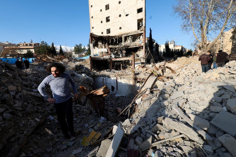 Un homme se tient au milieu des décombres d'un immeuble détruit par une frappe, dans le contexte du conflit israélo-américain avec l'Iran, à Téhéran, en Iran, samedi 21 mars 2026.