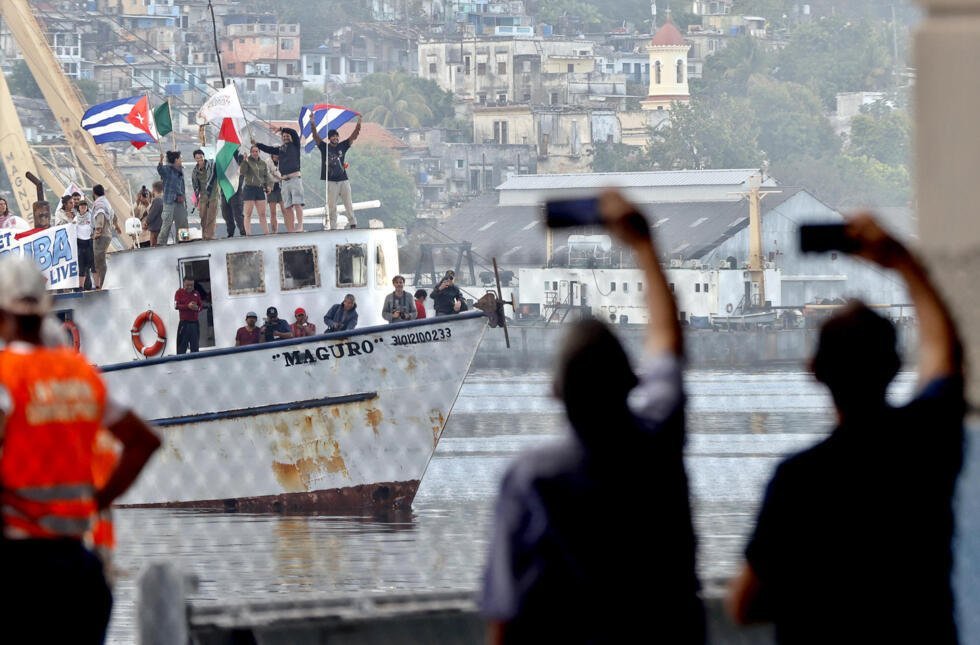 Integrantes del Convoy Nuestra América saludan a su llegada al puerto este martes, en La Habana (Cuba). El Convoy Nuestra América, inspirado en la Flotilla Global Sumud que en 2025 llevó ayuda humanitaria a Gaza, persigue enviar una señal de apoyo político a Cuba, que sufre desde enero un bloqueo petrolero por parte de EE.UU.
