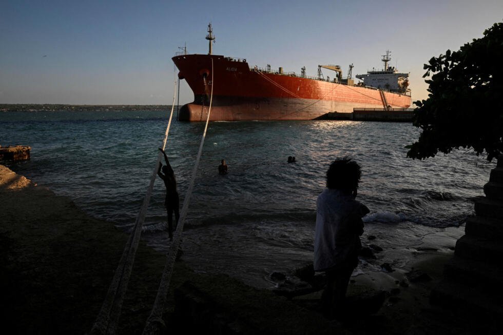 Varias personas pasan tiempo cerca del petrolero Alicia, con bandera cubana, atracado en la terminal de Matanzas, mientras Cuba espera la llegada del petrolero Anatoly Kolodkin, con bandera rusa, cargado de petróleo, en medio de una crisis energética que se prolonga desde hace meses, cuando la administración del presidente estadounidense Donald Trump cortó el suministro de combustible. La imagen se encuentra en Matanzas, Cuba, el 30 de marzo de 2026.
